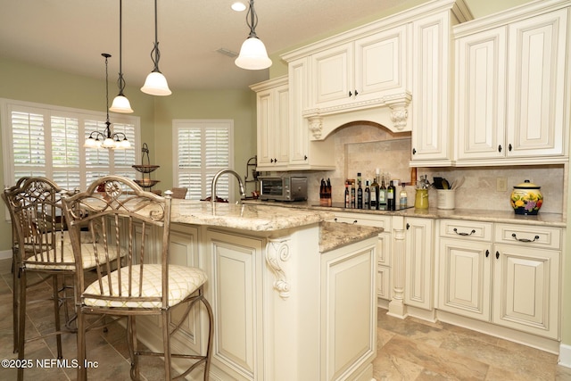 3771 Saltmeadow Ct S, Jacksonville, FL 32224 - kitchen with cream cabinetry, decorative backsplash, and light stone countertops