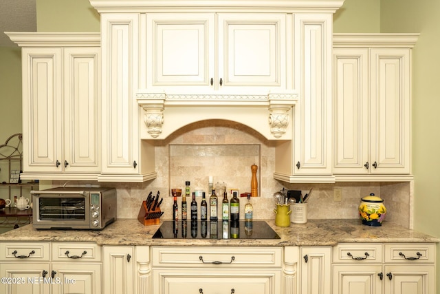 3771 Saltmeadow Ct S, Jacksonville, FL 32224 - kitchen featuring cream cabinetry, black electric stovetop, tasteful backsplash, and light stone countertops