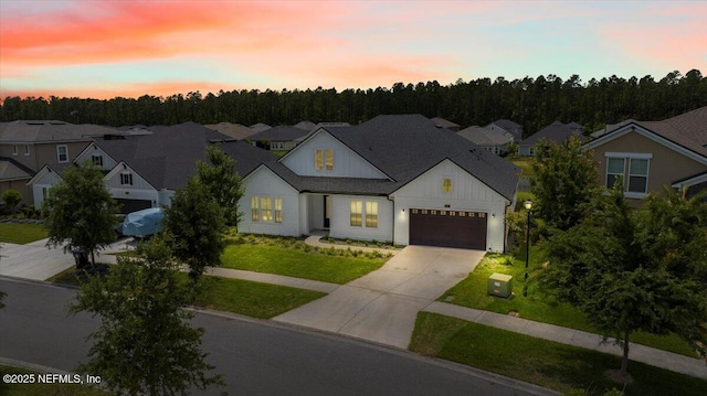 982 Oakland Hills Ave, Middleburg, FL 32068 - view of front of house with a lawn, board and batten siding, an attached garage, driveway, and a residential view