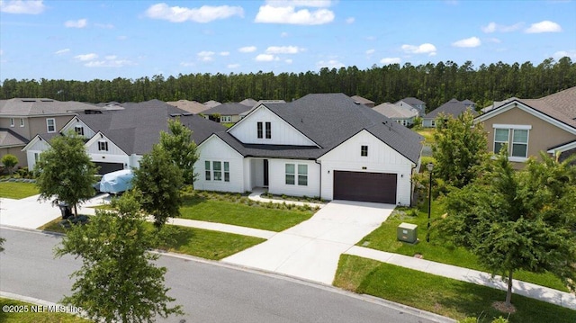 982 Oakland Hills Ave, Middleburg, FL 32068 - view of front facade with board and batten siding, concrete driveway, a residential view, and a front yard