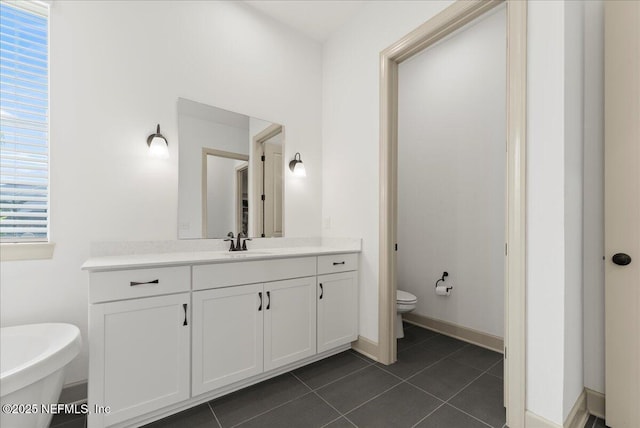 982 Oakland Hills Ave, Middleburg, FL 32068 - full bathroom featuring a freestanding bath, vanity, toilet, tile patterned floors, and baseboards