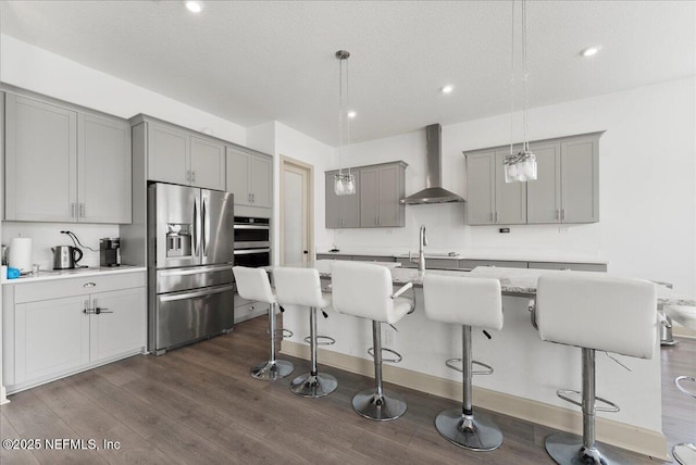 982 Oakland Hills Ave, Middleburg, FL 32068 - kitchen with wall chimney range hood, appliances with stainless steel finishes, gray cabinetry, and dark wood-style floors
