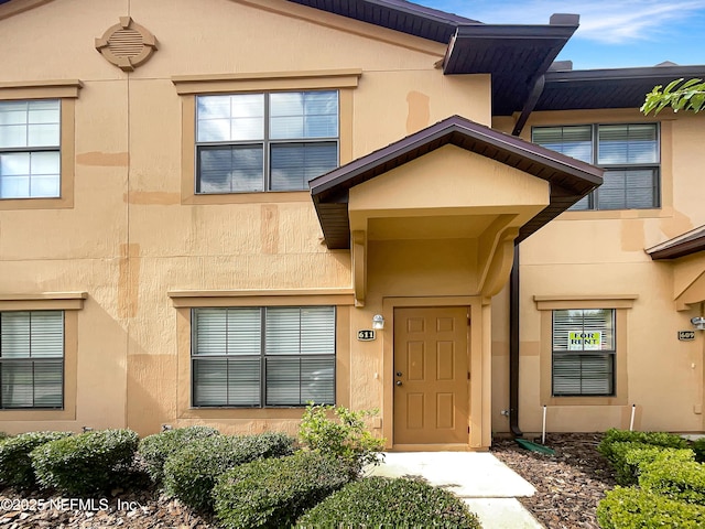 entrance to property featuring stucco siding