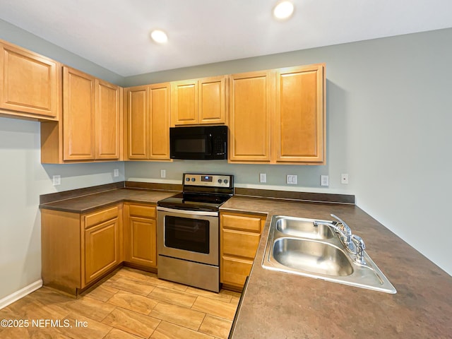 kitchen with recessed lighting, dark countertops, a sink, black microwave, and stainless steel range with electric stovetop