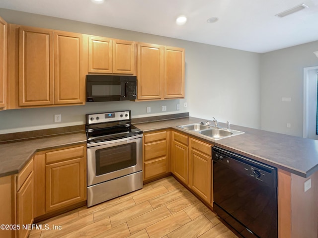 kitchen with black appliances, a sink, a peninsula, and dark countertops