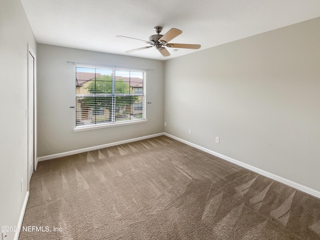 spare room with carpet flooring, ceiling fan, and baseboards