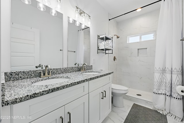 bathroom with double vanity, a sink, marble finish floor, and a shower stall