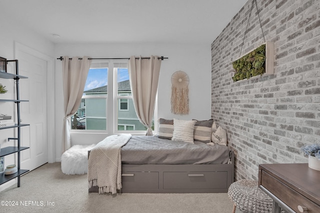 bedroom featuring brick wall and carpet floors