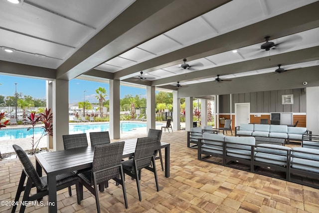 view of patio / terrace featuring ceiling fan, outdoor lounge area, a community pool, and outdoor dining area
