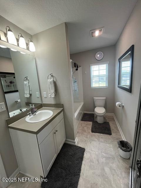 full bath with vanity, baseboards, toilet, and shower / washtub combination