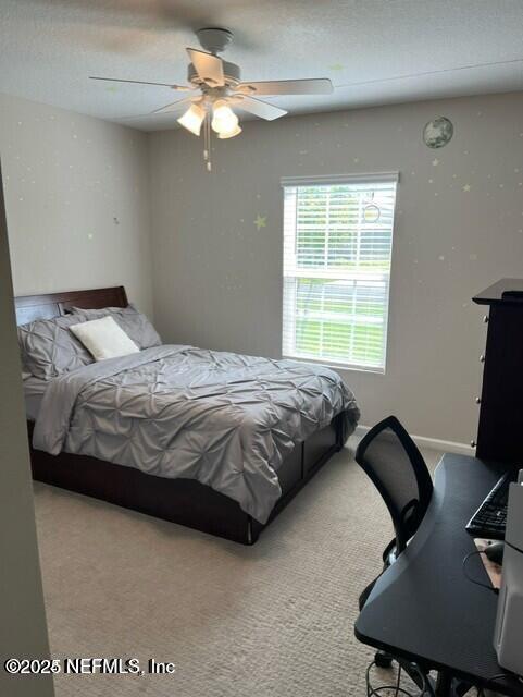 carpeted bedroom with baseboards and ceiling fan