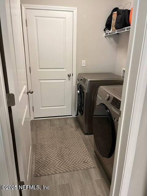 laundry area featuring laundry area, wood finish floors, and separate washer and dryer
