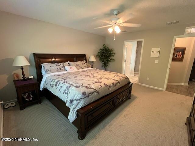 bedroom featuring baseboards, visible vents, light carpet, and ceiling fan
