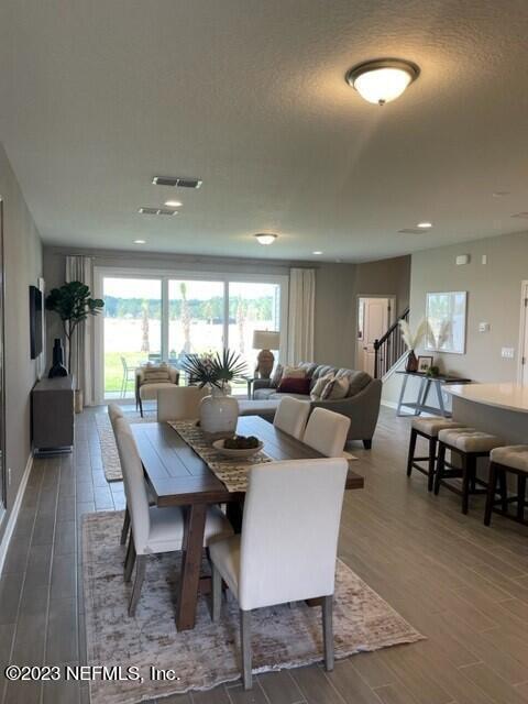 dining space with wood finished floors, plenty of natural light, and visible vents
