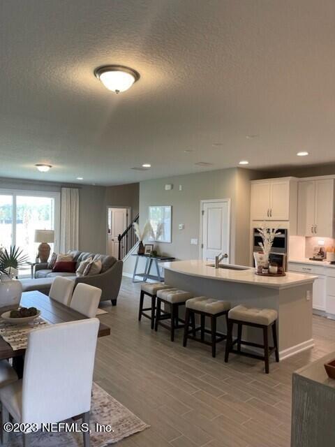 interior space featuring recessed lighting, stairs, a textured ceiling, and light wood-style flooring