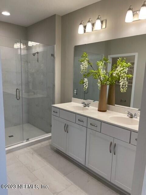full bath with recessed lighting, marble finish floor, a sink, and a shower stall