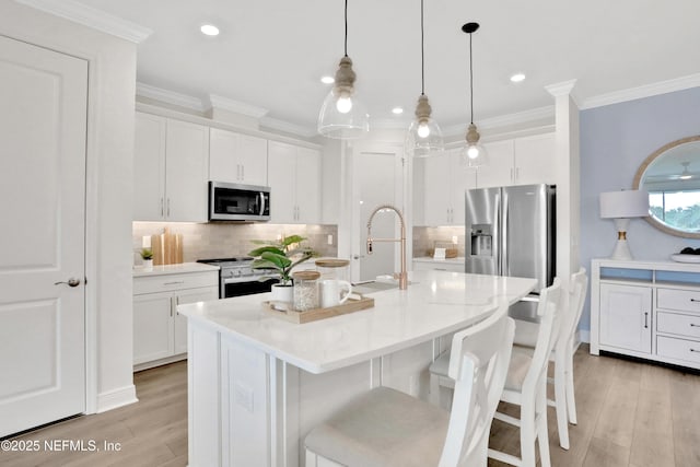 kitchen featuring a kitchen breakfast bar, appliances with stainless steel finishes, decorative backsplash, and light wood-type flooring