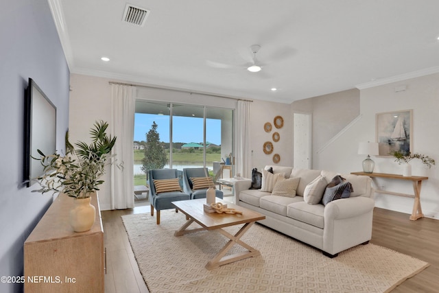 living area with recessed lighting, wood finished floors, ceiling fan, visible vents, and crown molding