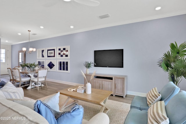 living area featuring baseboards, recessed lighting, wood finished floors, and crown molding