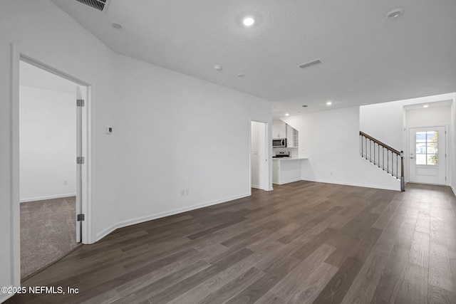 unfurnished living room featuring stairway, dark wood-style flooring, and baseboards