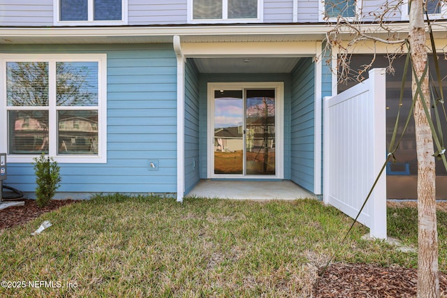 view of exterior entry with a lawn