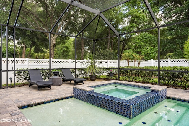 view of swimming pool with a pool with connected hot tub, fence, and a patio area