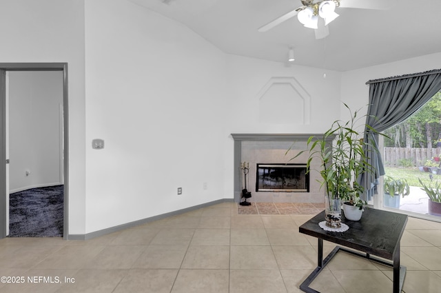1558 Roseberry Ct, Fleming Island, FL 32003 - living area featuring a tile fireplace, vaulted ceiling, baseboards, a ceiling fan, and light tile patterned flooring