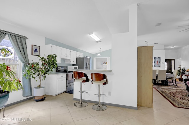 1558 Roseberry Ct, Fleming Island, FL 32003 - kitchen featuring a breakfast bar area, white cabinetry, stainless steel appliances, light countertops, and vaulted ceiling