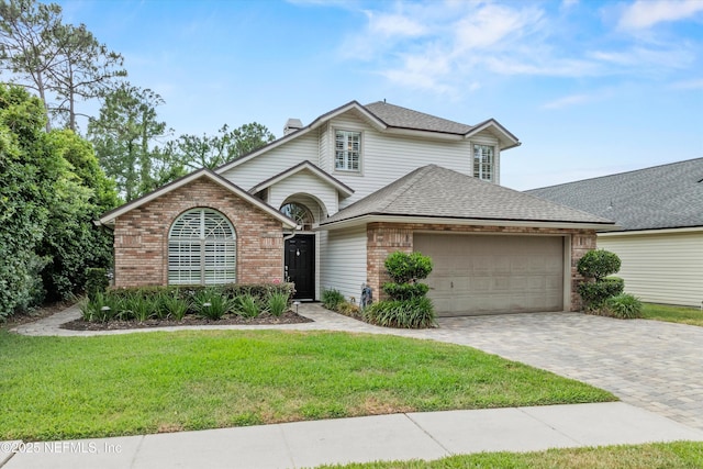1576 Linkside Dr, Fleming Island, FL 32003 - traditional home with brick siding, an attached garage, a front yard, a chimney, and a shingled roof