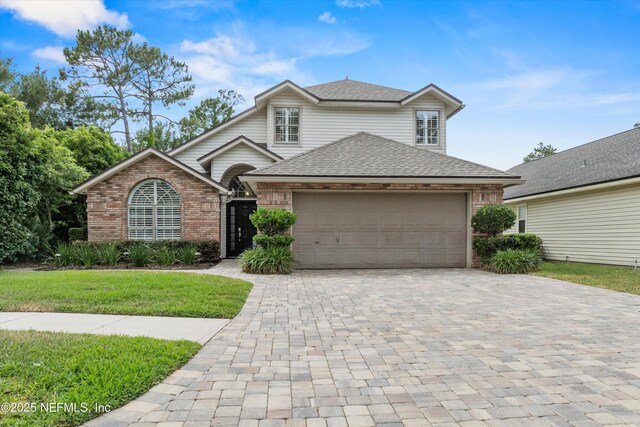 1576 Linkside Dr, Fleming Island, FL 32003 - traditional home featuring brick siding, decorative driveway, a garage, roof with shingles, and a front yard
