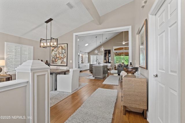 1576 Linkside Dr, Fleming Island, FL 32003 - hall featuring vaulted ceiling, a chandelier, and hardwood / wood-style flooring