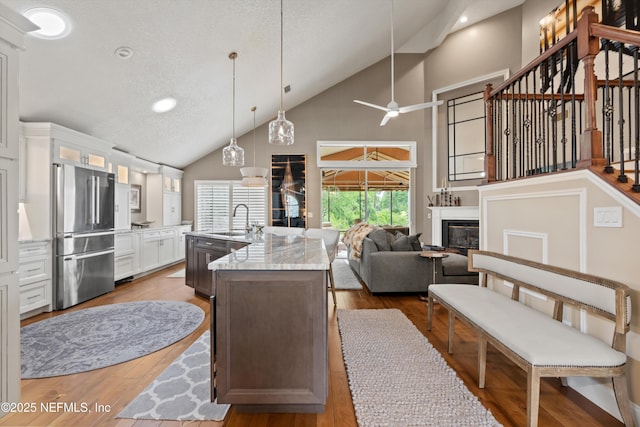 1576 Linkside Dr, Fleming Island, FL 32003 - kitchen with high end refrigerator, high vaulted ceiling, a sink, open floor plan, and glass insert cabinets
