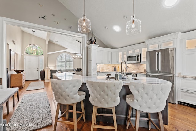 1576 Linkside Dr, Fleming Island, FL 32003 - kitchen featuring stainless steel appliances, decorative backsplash, wood finished floors, light stone counters, and white cabinetry