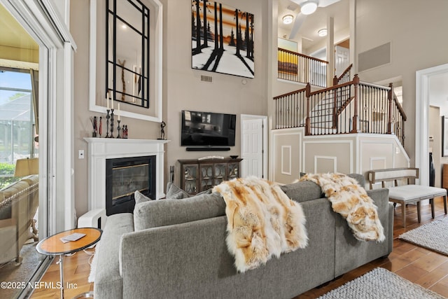 1576 Linkside Dr, Fleming Island, FL 32003 - living area featuring stairs, wood finished floors, a high ceiling, and a glass covered fireplace