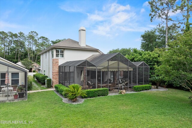 1576 Linkside Dr, Fleming Island, FL 32003 - rear view of house featuring a yard, a chimney, and a shingled roof