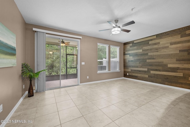 133 San Briso Way, Saint Augustine, FL 32092 - empty room featuring a ceiling fan, wood walls, light tile patterned floors, and an accent wall