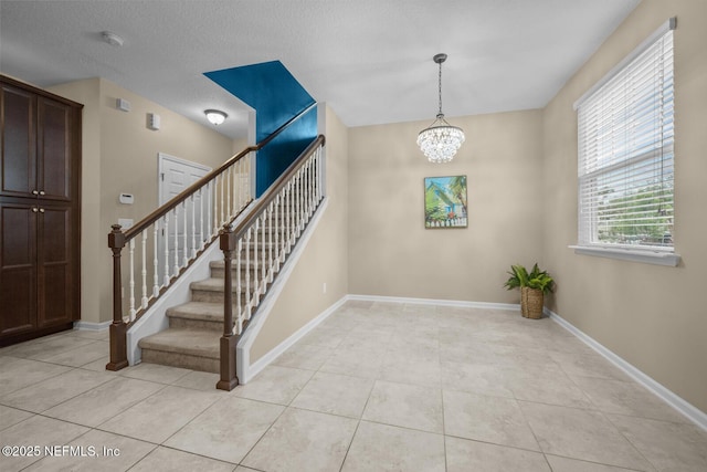 133 San Briso Way, Saint Augustine, FL 32092 - stairway with tile patterned floors and a chandelier