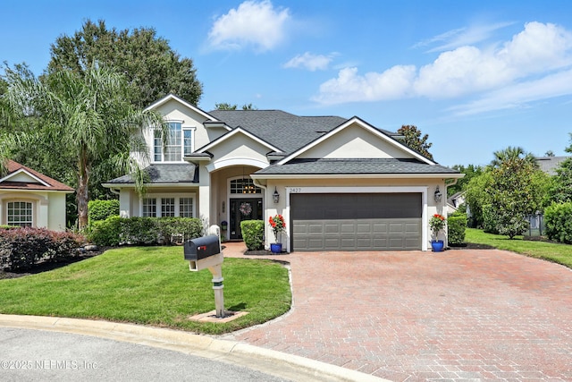 2427 Green Glade Ct, Fleming Island, FL 32003 - view of front of home with stucco siding, a garage, decorative driveway, and a front yard