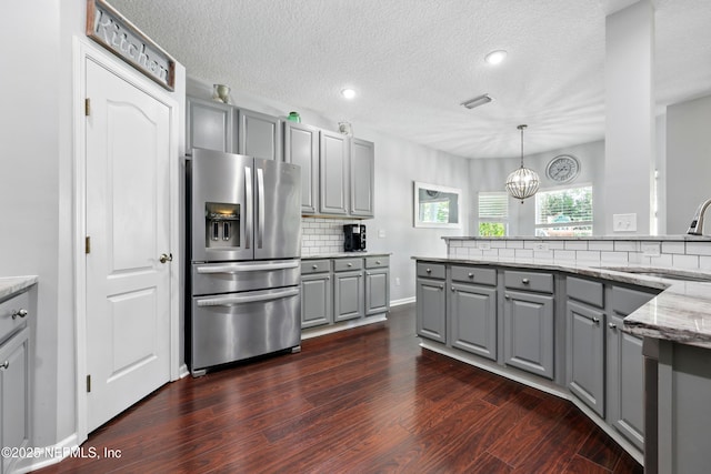 2427 Green Glade Ct, Fleming Island, FL 32003 - kitchen with gray cabinetry, stainless steel fridge, a sink, backsplash, and dark wood-style floors