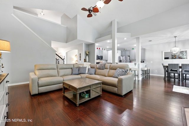 2427 Green Glade Ct, Fleming Island, FL 32003 - living room featuring dark wood-style floors, a ceiling fan, baseboards, stairs, and arched walkways