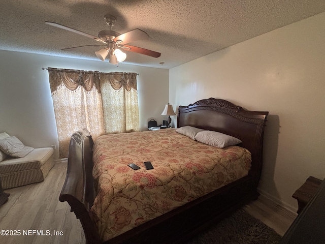 bedroom with a textured ceiling, ceiling fan, and wood finished floors