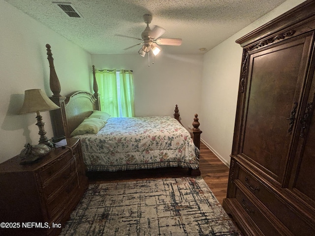 bedroom featuring a ceiling fan, dark wood-style flooring, a textured ceiling, and visible vents