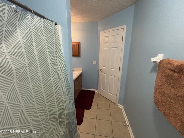 bathroom featuring a shower with curtain, a textured ceiling, vanity, tile patterned floors, and baseboards