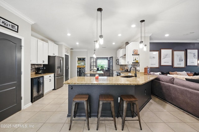 kitchen featuring wine cooler, stainless steel fridge with ice dispenser, tasteful backsplash, and a sink