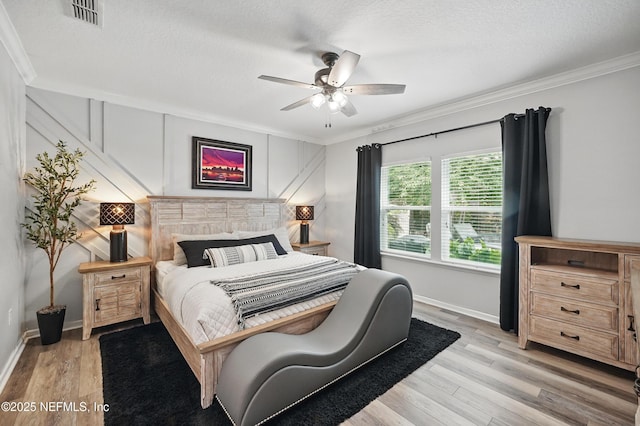 bedroom featuring crown molding, baseboards, light wood-style flooring, and visible vents