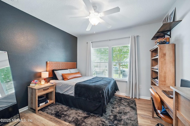 bedroom with baseboards, ceiling fan, and wood finished floors
