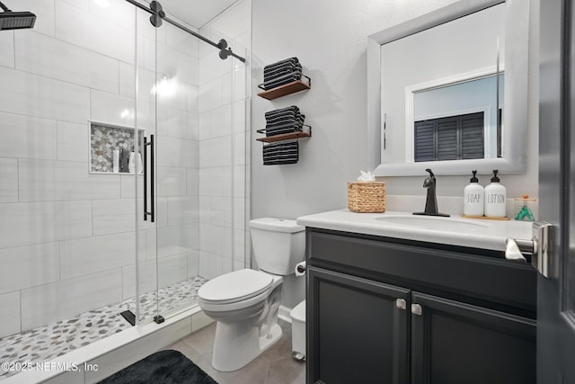 full bathroom featuring vanity, a stall shower, and toilet