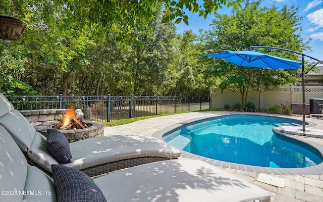 view of swimming pool featuring a fenced in pool, a fenced backyard, an outdoor fire pit, and a patio area