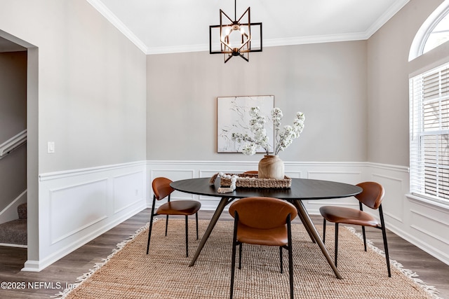 dining room featuring crown molding, an inviting chandelier, a wainscoted wall, stairs, and wood finished floors