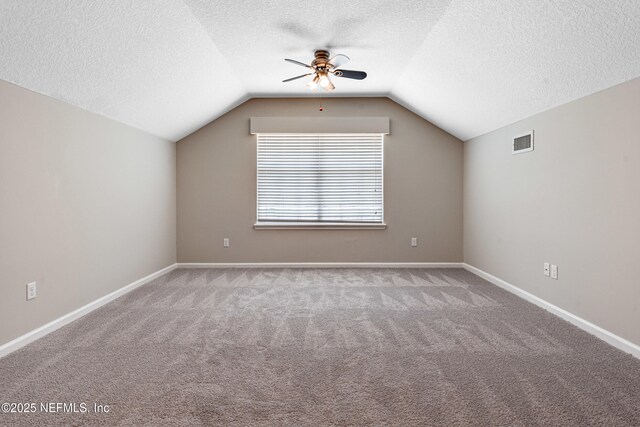 bonus room with visible vents, carpet floors, lofted ceiling, a textured ceiling, and a ceiling fan